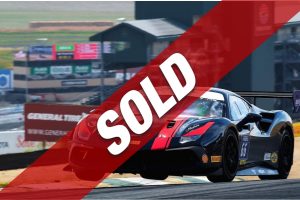Race car speeding on a race track with a bold red SOLD diagonal banner across the image