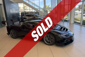 Showroom with luxury cars and a red 'SOLD' banner across the image indicating sold inventory.