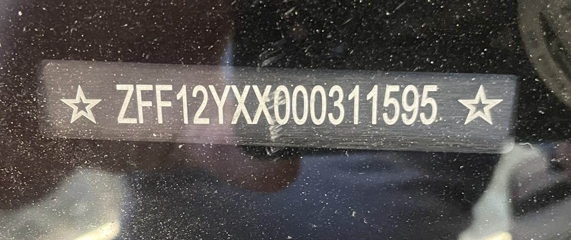 VIN_IMG_8600 – Sage Auto Sport VIN plate on a car window showing ZFF12YXX000311595 with stars on both ends