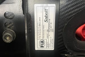 IMG_4468 – Sage Auto Sport Close-up of a vehicle door jamb label showing model and serial numbers for manufacturer identification and compliance.
