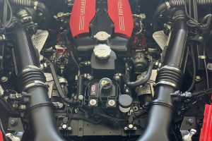 IMG_4481 – Sage Auto Sport Ferrari engine bay with red intake covers and surrounding hoses and components, viewed from above.